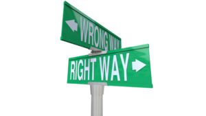 A green two-way street sign pointing to Right Way and Wrong Way